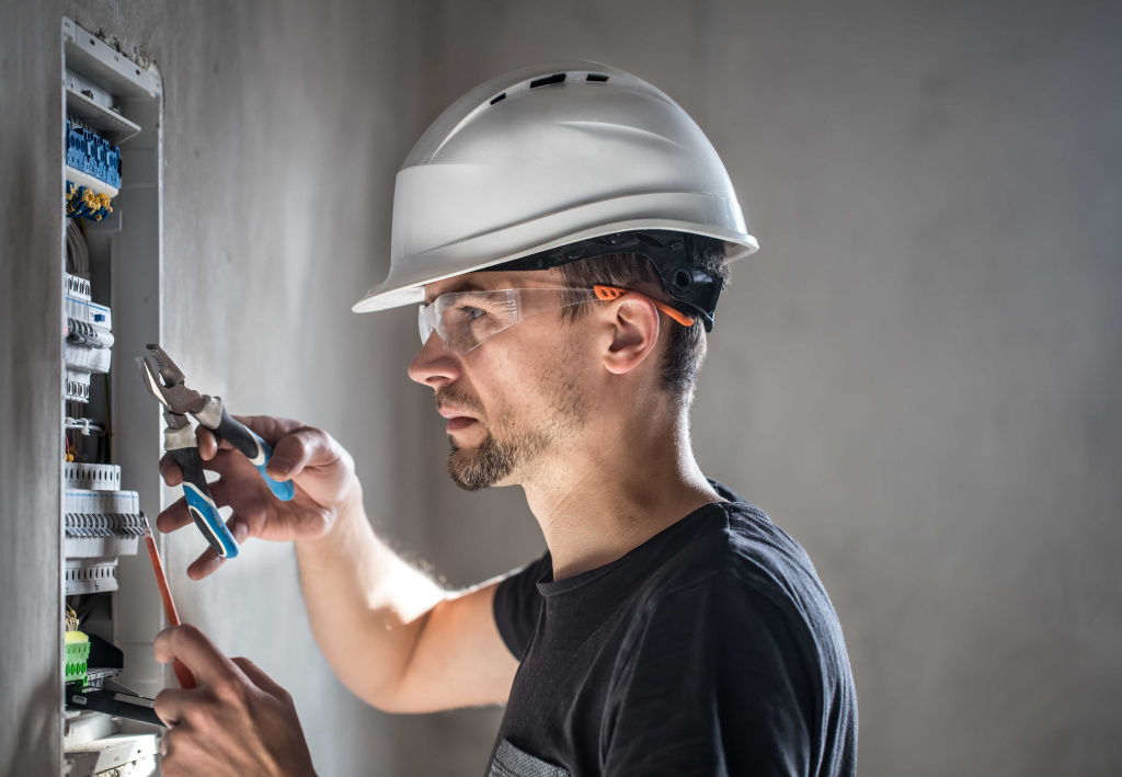man-electrical-technician-working-switchboard-with-fuses-installation-connection-electrical-equipment (1).jpg Безопасность низковольтного оборудования